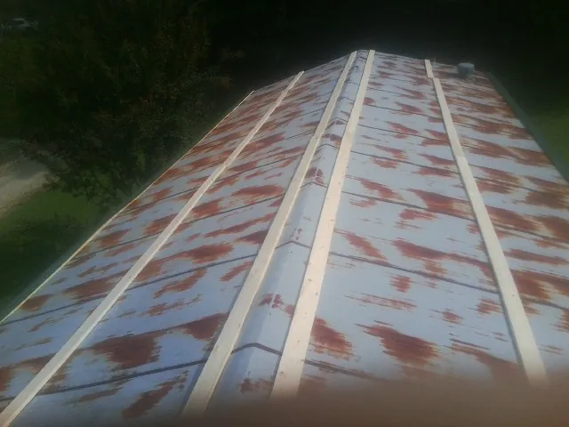 Rusted metal roof panels with new wood purlins before replacement — Storm Damage Roof Repair in Brownsville by Roofing Brothers