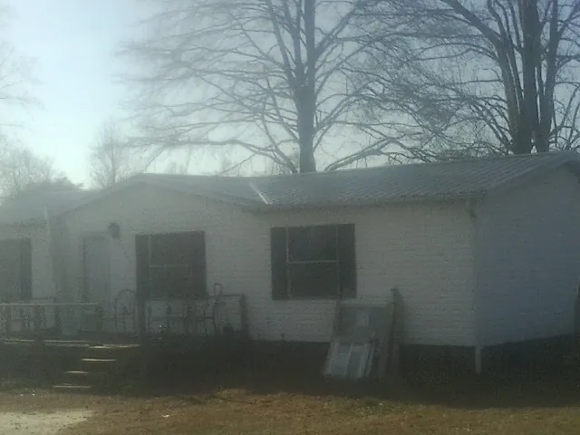 New metal roof on a white painted brick home on a foggy morning in Brownsville